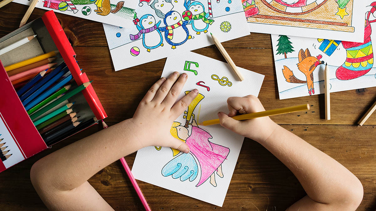 Child's hands coloring on wooden table