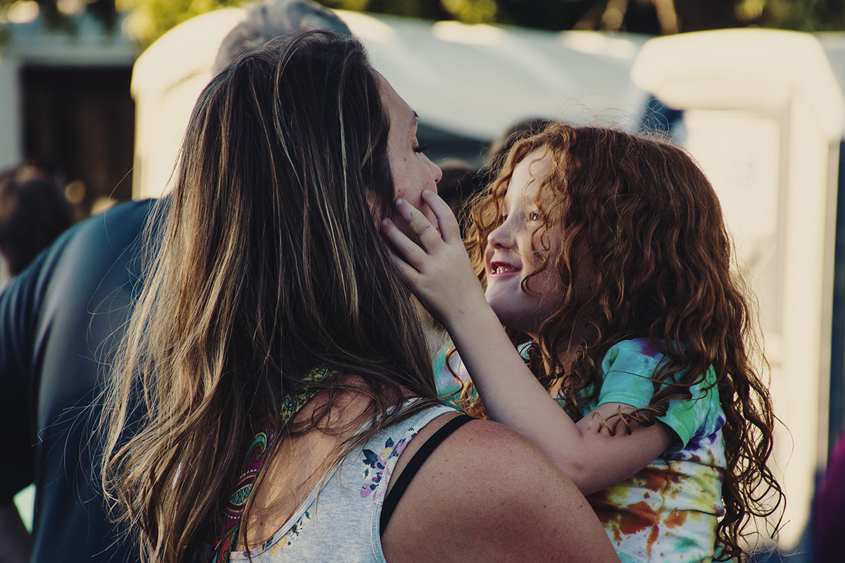 Photo of a smiling girl in her mom's arms