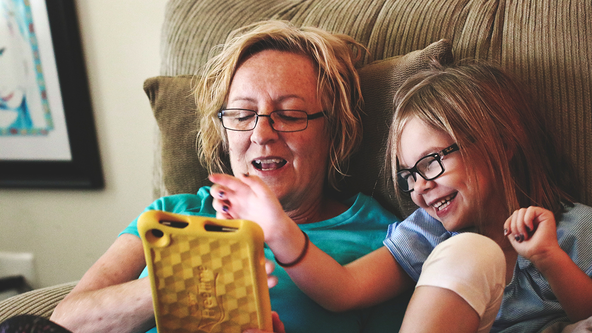 Family time: a woman and girl are smiling as they use a tablet computer together. Photo by Michael Morse from Pexels.