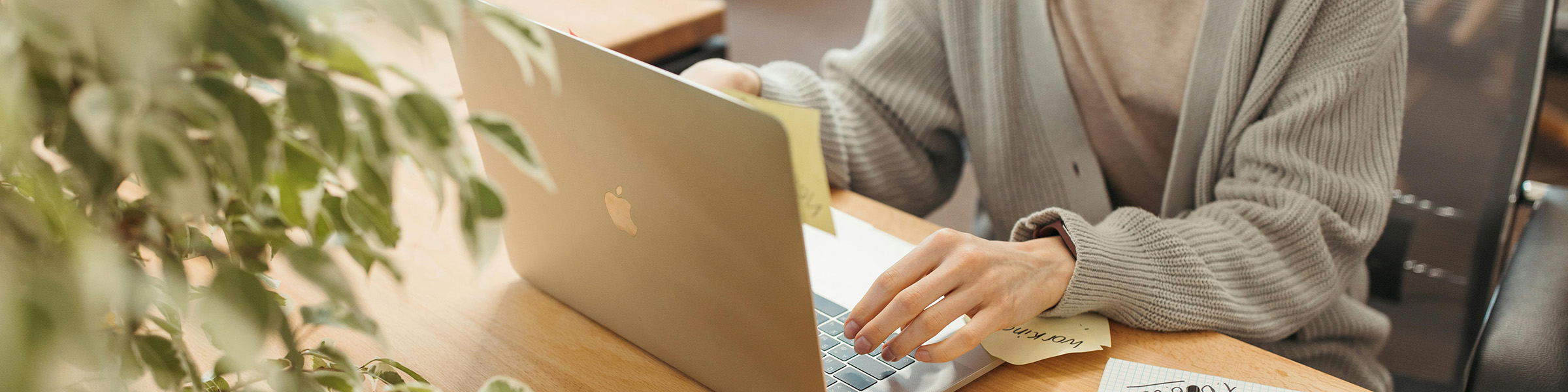 A woman reads online news at her laptop at work